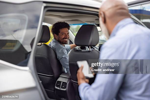 crowdsourcing-taxifahrer, der einen fahrgast aufnimmt und lächelt - fahrgemeinschaft stock-fotos und bilder
