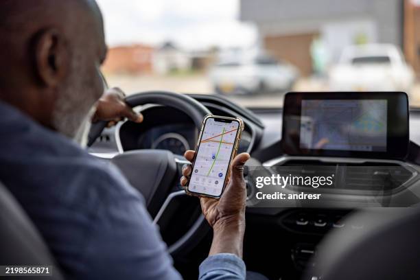 uomo anziano che utilizza un'app di navigazione mentre guida la sua auto - trasporto collettivo foto e immagini stock