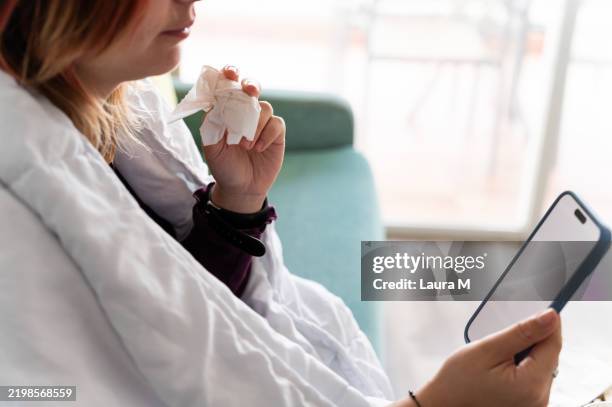 sick young woman having online medical consultation at home - facial tissue stock pictures, royalty-free photos & images
