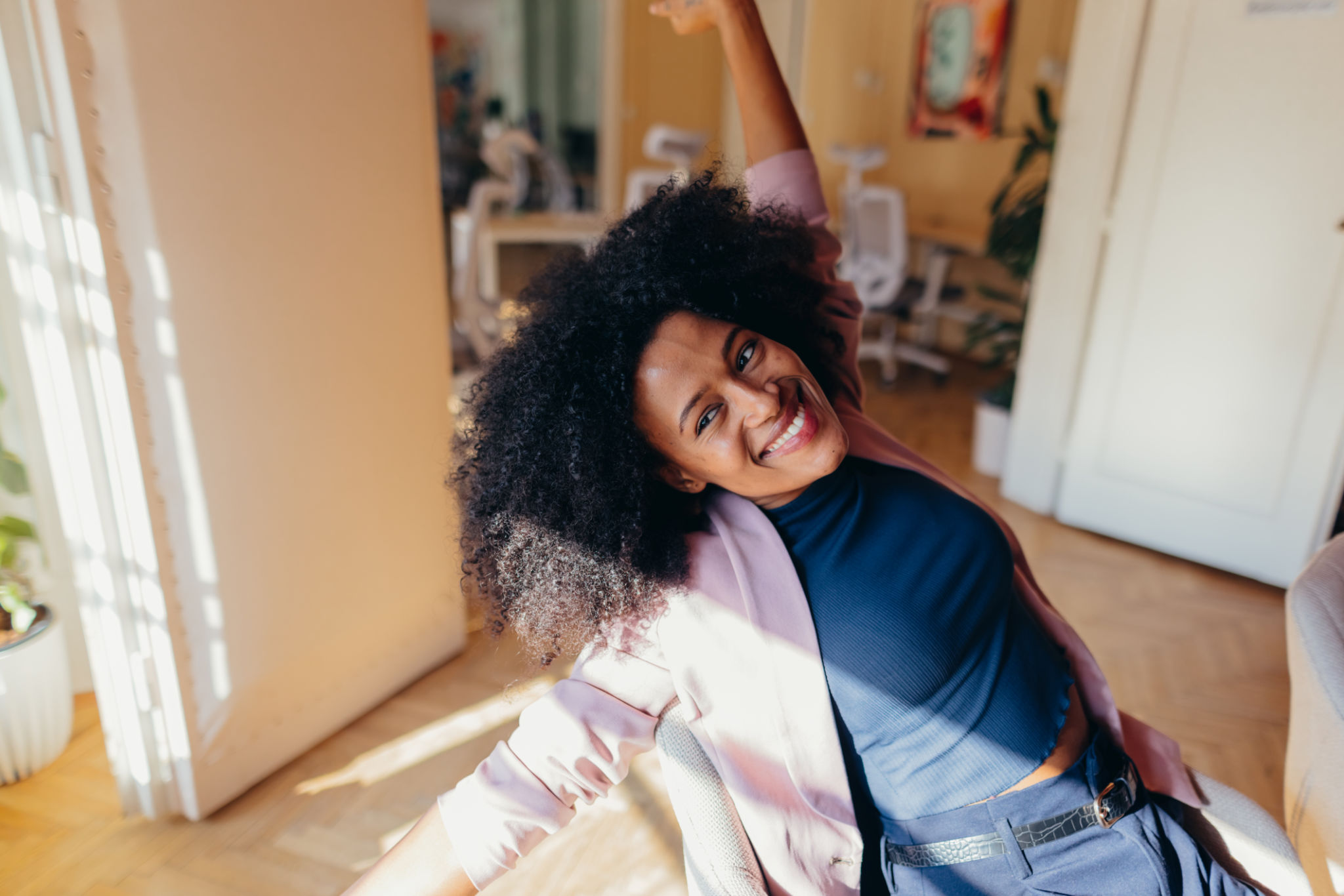 Young businesswoman relaxing on chair with arms raised and smiling Young businesswoman relaxing on chair with arms raised and smiling