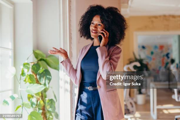 confident young businesswoman talking on the phone in modern office - img_1850 stock pictures, royalty-free photos & images