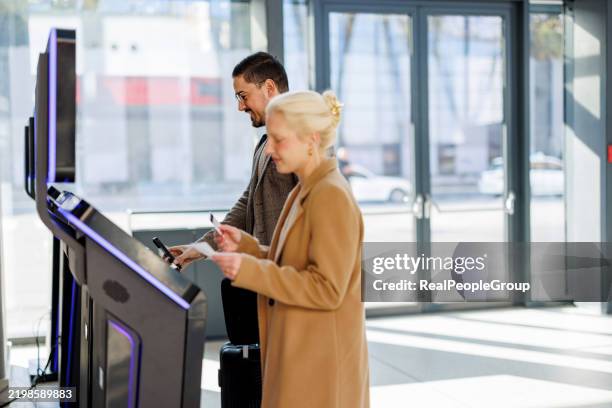 passengers using self check-in kiosk at railroad station - self service check in stock pictures, royalty-free photos & images