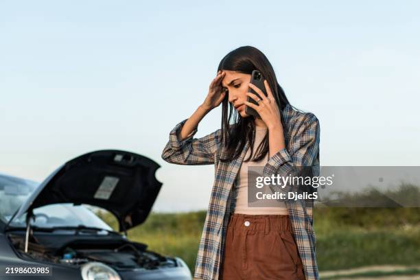woman having car problems and using phone to call for help - tow truck stock pictures, royalty-free photos & images
