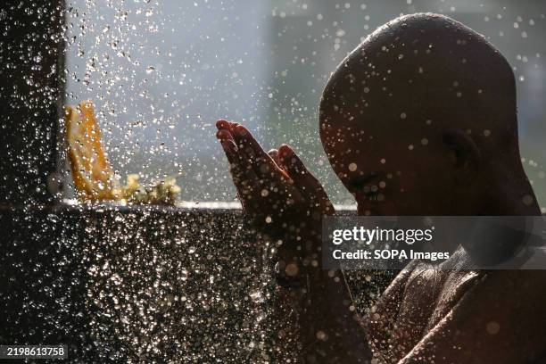 Indian Purification Ritual A young Hindu devotee washes his body as a purification ritual during ...