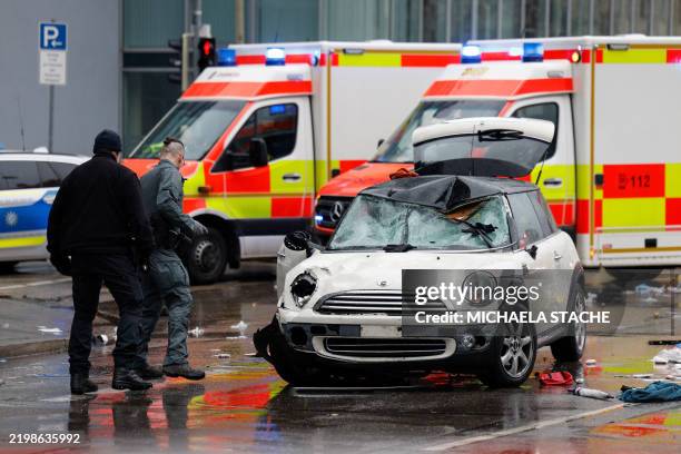 Members of the emergency services work at the scene where a car drove into a crowd in the southern German city of Munich on February 13, 2025 leaving...