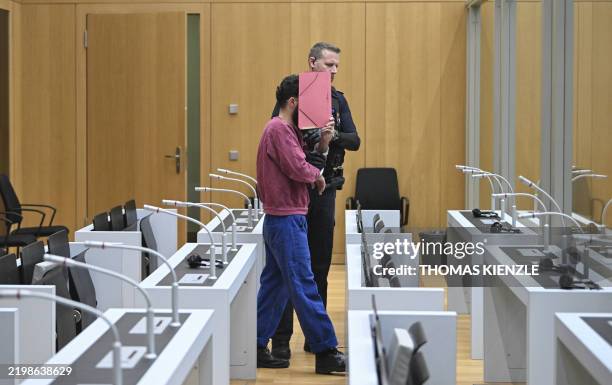 The defendant arrives in the courtroom of the Higher Regional Court in Stuttgart-Stammheim, southern Germany, on February 13 before the start of his...