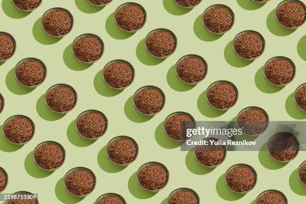 repeated bowls with flax seeds on the green background - graine de lin photos et images de collection