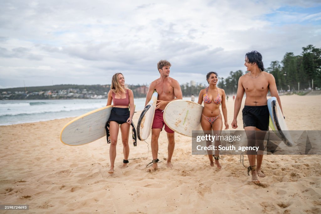 Summer surfers walk along Bondi Beach in Sydney, embracing friendship and vibrant Australian culture