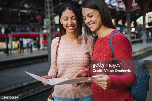 Checvking A Rmap Two Smiling Tourists Checking A Map In A Train Station High-Res Stock ...