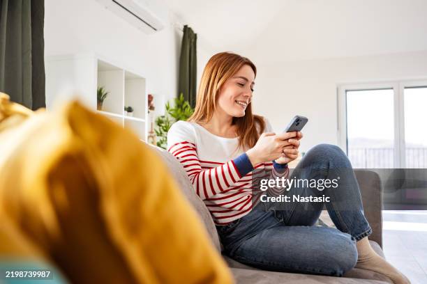 frau, die die online-app auf dem telefon benutzt - generation y stock-fotos und bilder