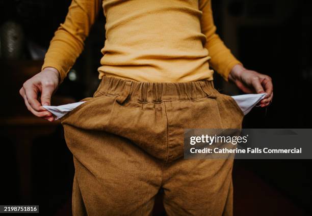 conceptual image of a child turning their empty pockets inside-out - deficiencia condición fotografías e imágenes de stock