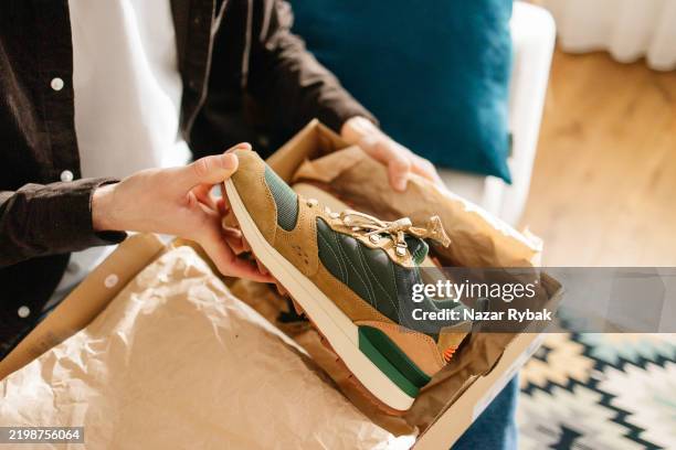 homme méconnaissable déballant de nouvelles chaussures à partir d’un achat en ligne à la maison - chaussures photos et images de collection