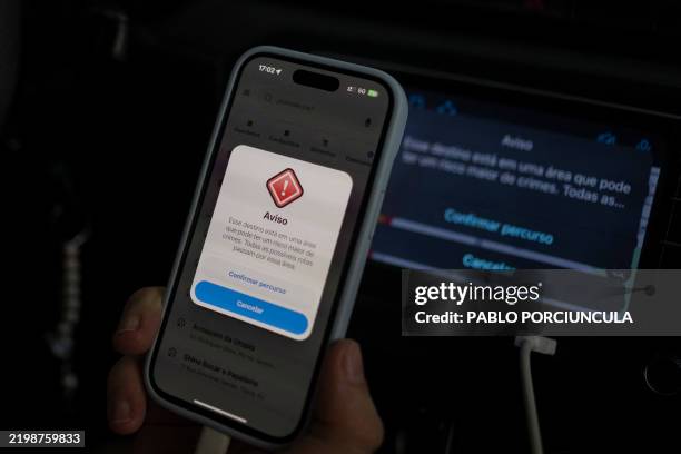 An Uber driver show his cellphone with warning from the Waze app that says: This destination is in an area that may have a higher risk of crime...
