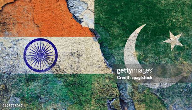 indian and pakistani flag on cracked wall - india-pakistan relations: border and political tensions - pakistan flag stock pictures, royalty-free photos & images