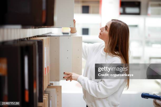 designer choosing materials from samples at interior design shop - retail interior design stock pictures, royalty-free photos & images