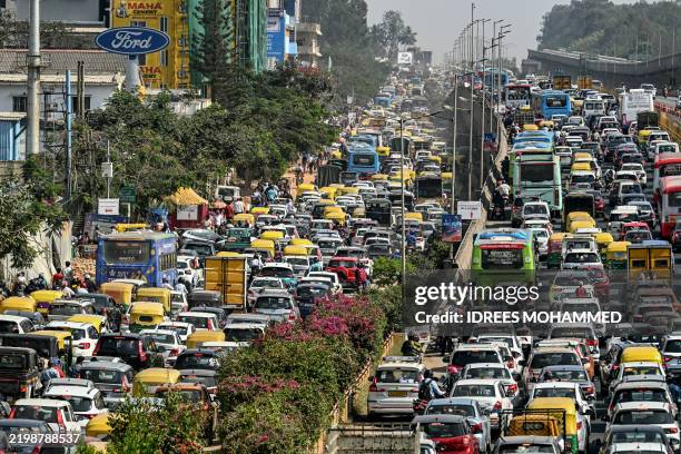 Commuters wait in a traffic jam along a road leading to the Yelahanka Air Force Station in Bengaluru on February 14, 2025.