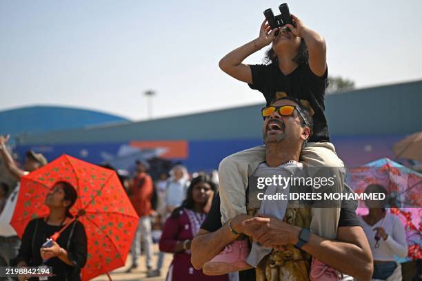 Visitors watch a flying display during the 15th edition of Aero India 2025 at Yelahanka Air Force Station in Bengaluru on February 14, 2025.