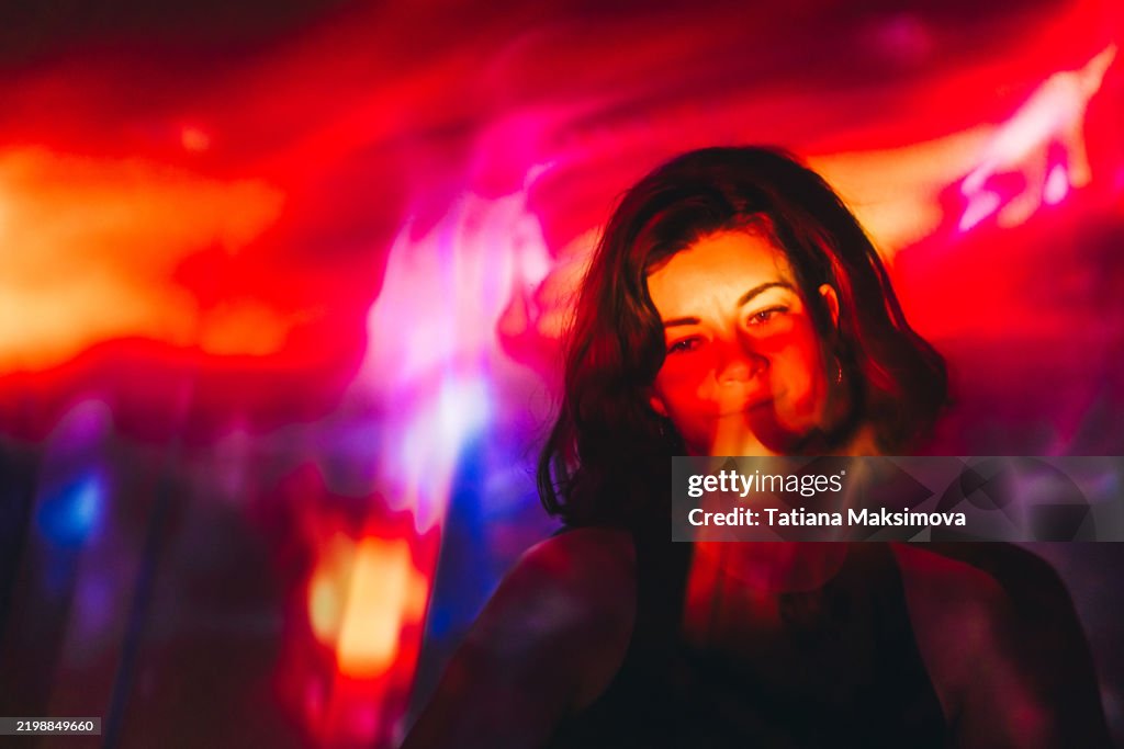 A beautiful woman portrait in dark, projection of abstract light on her.