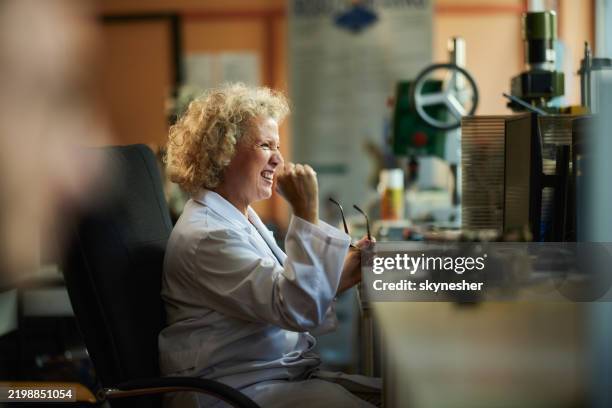 happy female scientist celebrating success while working on desktop pc. - finding stock pictures, royalty-free photos & images