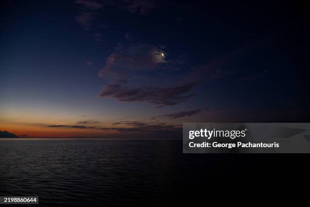 tranquil twilight seascape with moon and clouds - clair de lune photos et images de collection
