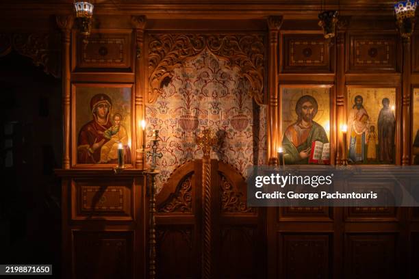 ornate orthodox iconostasis illuminated by candlelight - griechisch orthodoxe kirche stock-fotos und bilder