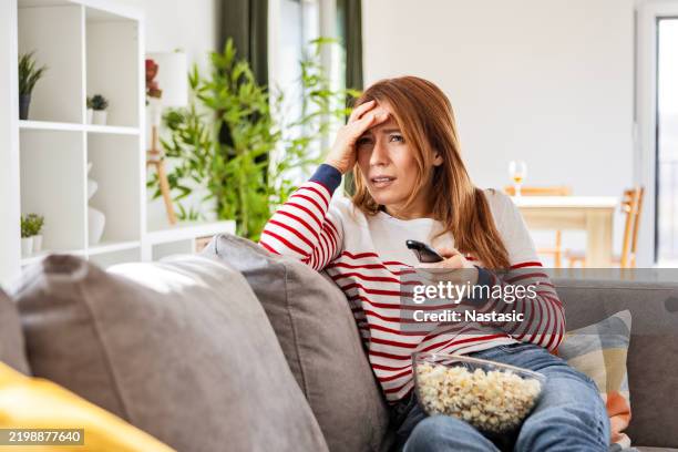 woman watching a scary film at home - tv addict stock pictures, royalty-free photos & images