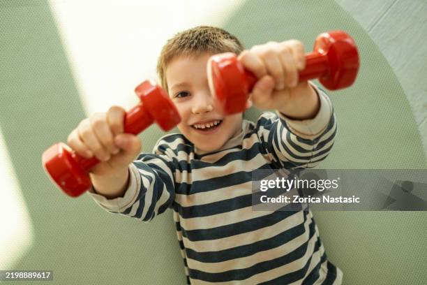 little boy playing with dumbbells in the living room - home workout kids stock pictures, royalty-free photos & images