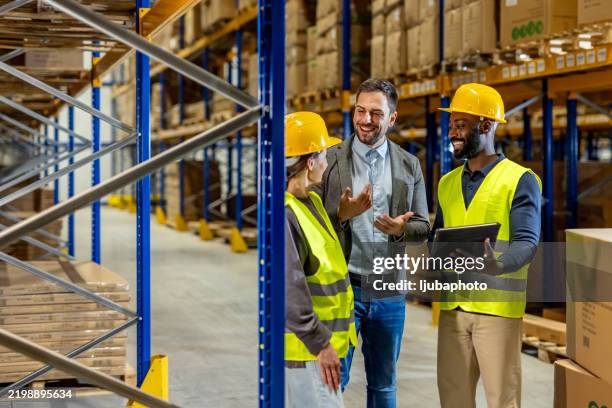 warehouse team engaged in discussion with supervisor during inventory check process - força operacional imagens e fotografias de stock