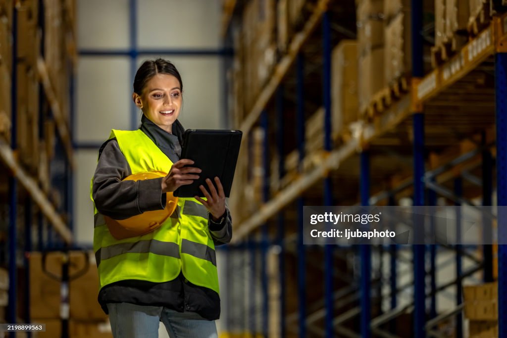 Warehouse Worker Using a Digital Tablet for Inventory Management