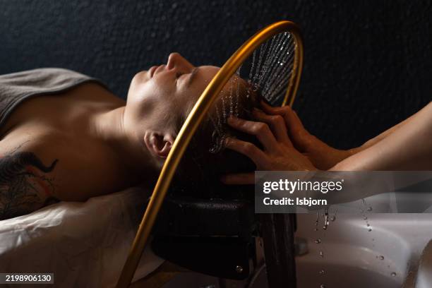 masajista que masajea la cabeza y el cabello para una mujer en un salón de spa. - foto de cabeza fotografías e imágenes de stock