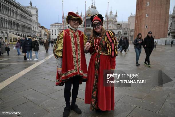Revellers wearing period costumes pose during the traditional Venice Carnival, starting today on February 14, 2025. This year, the theme of one of...