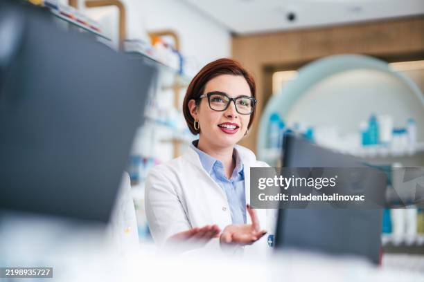 happy female pharmacist at work - apotheker stockfoto's en -beelden