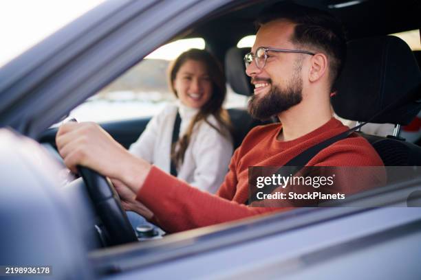 a man and a woman are traveling by car - woman driving husband stock pictures, royalty-free photos & images