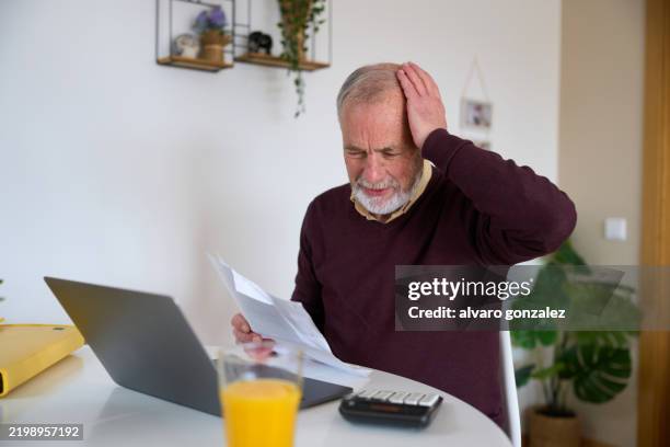 stressed senior man managing domestic finances at home - pensão documento bancário imagens e fotografias de stock