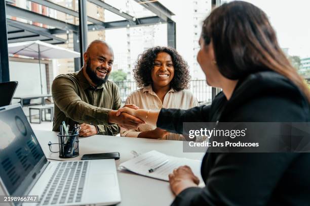 couple closing real estate contract with real estate agent - sälja bildbanksfoton och bilder