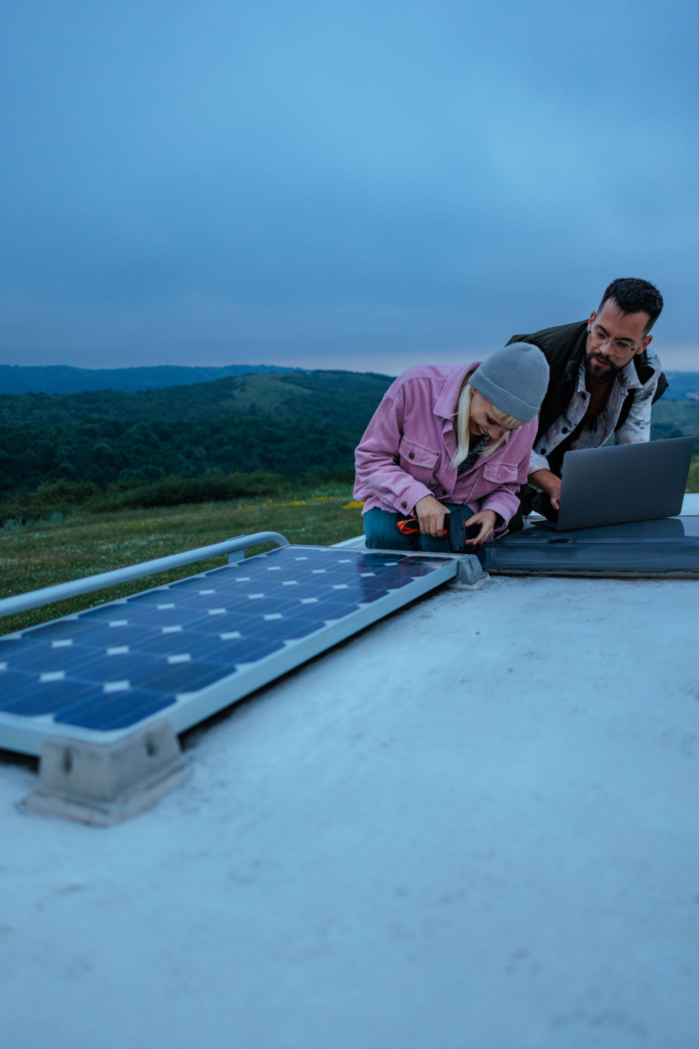 Technicians installing solar panel on camper van roof Technicians installing solar panel on camper van roof