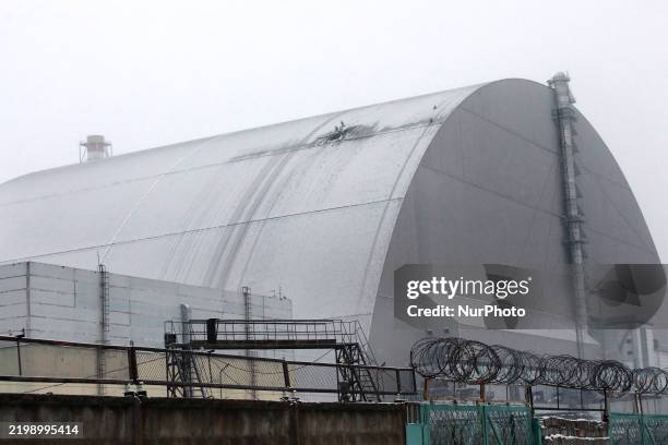 Rescuers work at the site where a Russian attack drone with an explosive warhead hits the New Safe Confinement at the Chornobyl Nuclear Power Plant...