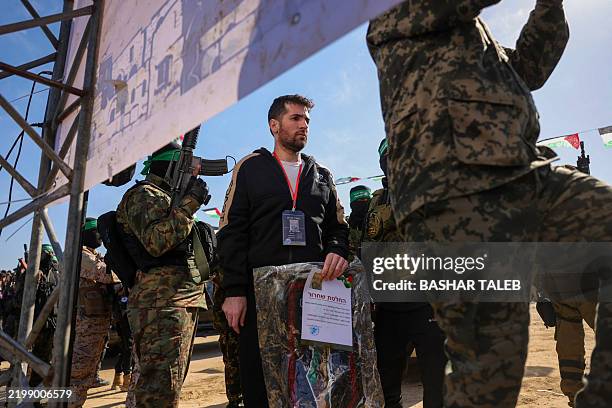 Hamas militants escort Israeli-American hotsage Sagui Dekel-Chen on a stage before handing him over to a Red Cross team in Khan Yunis, southern Gaza...