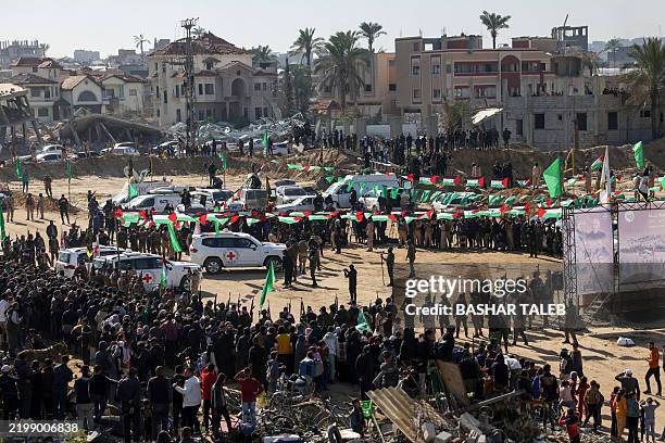 Red Cross vehicles wait at the spot where Hamas militants are expected to hand over Israeli hostages in Khan Yunis in the southern Gaza Strip on...
