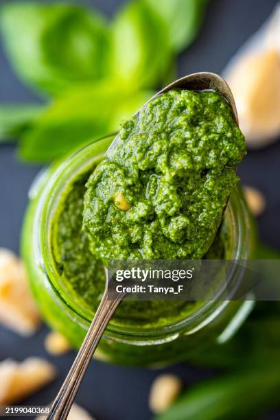 sauce pesto de basilic maison sur une cuillère avec ingrédients - pistou photos et images de collection