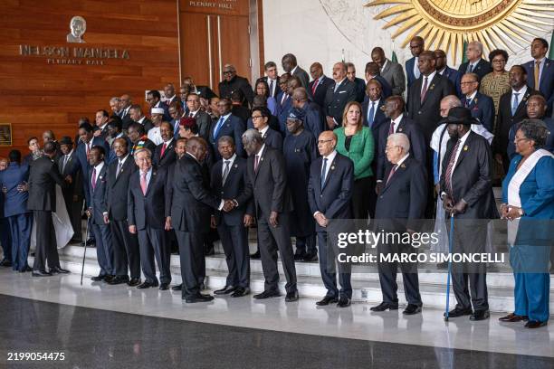 South African President Cyril Ramaphosa shakes hands with outgoing African Union Commission chairman Moussa Faki as African heads of state prepare...