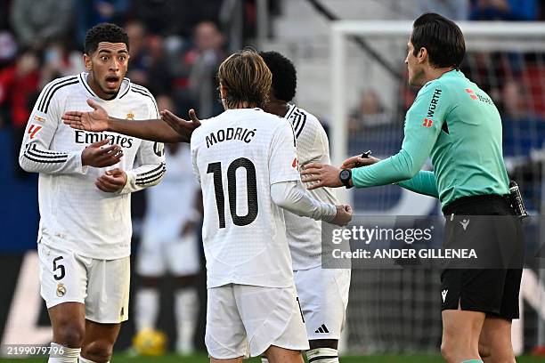 Real Madrid's English midfielder Jude Bellingham reacts to being presented a red card by Spanish referee Munuera Montero during the Spanish league...