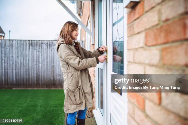 a woman unlocking front door and returning home - entered stock pictures, royalty-free photos & images