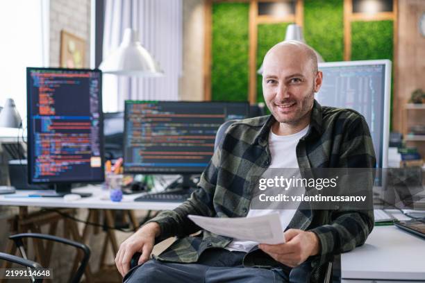 smiling it programmer working on desktop computer. male specialist creating innovative software. engineer developing app, program, video game. writing code in terminal - computer coding game stock pictures, royalty-free photos & images