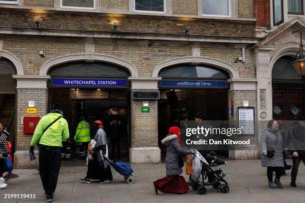 Members of the public outside Whitechapel Underground Station on February 12, 2025 in London, England. Bengali signage was installed at the station...
