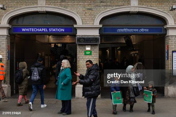 Members of the public outside Whitechapel Underground Station on February 12, 2025 in London, England. Bengali signage was installed at the station...