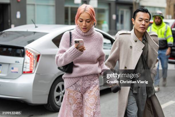 Tina Leung wears pink turtleneck knit, laced skirt, black bag outside Michael Kors during New York Fashion Week on February 11, 2025 in New York City.