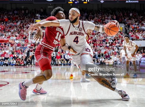 Johni Broome of the Auburn Tigers drives to the basket during the first half around Mouhamed Dioubate of the Alabama Crimson Tide at Coleman Coliseum...