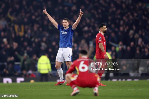 James Tarkowski of Everton celebrates after his goal stands following a VAR review as Trent Alexander-Arnold and Mohamed Salah of Liverpool look...