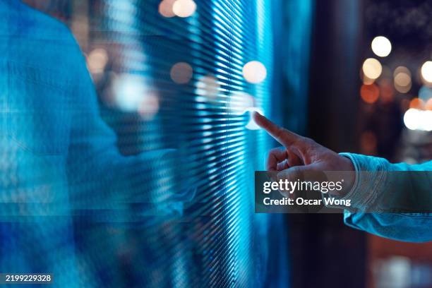 male hand touching a blue illuminated digital display - data points stock pictures, royalty-free photos & images